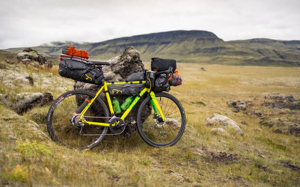 Gelbes Gravelbike mit Gepäck in der Landschaft